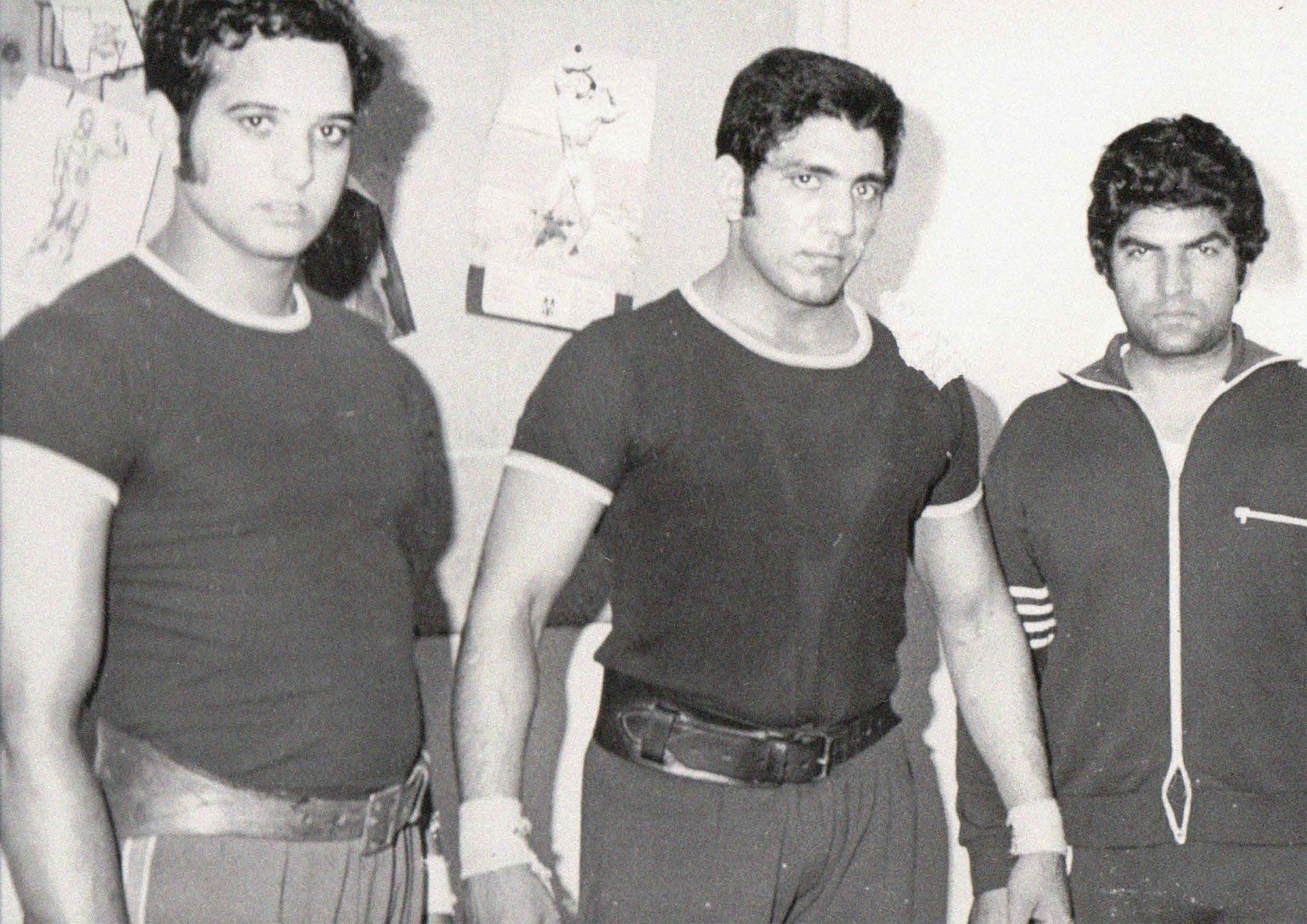 Three muscular young men (probably weightlifters) in sportswear, two with thick leather belts around their waists.