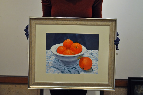 a painting of oranges on white lace against a blue background