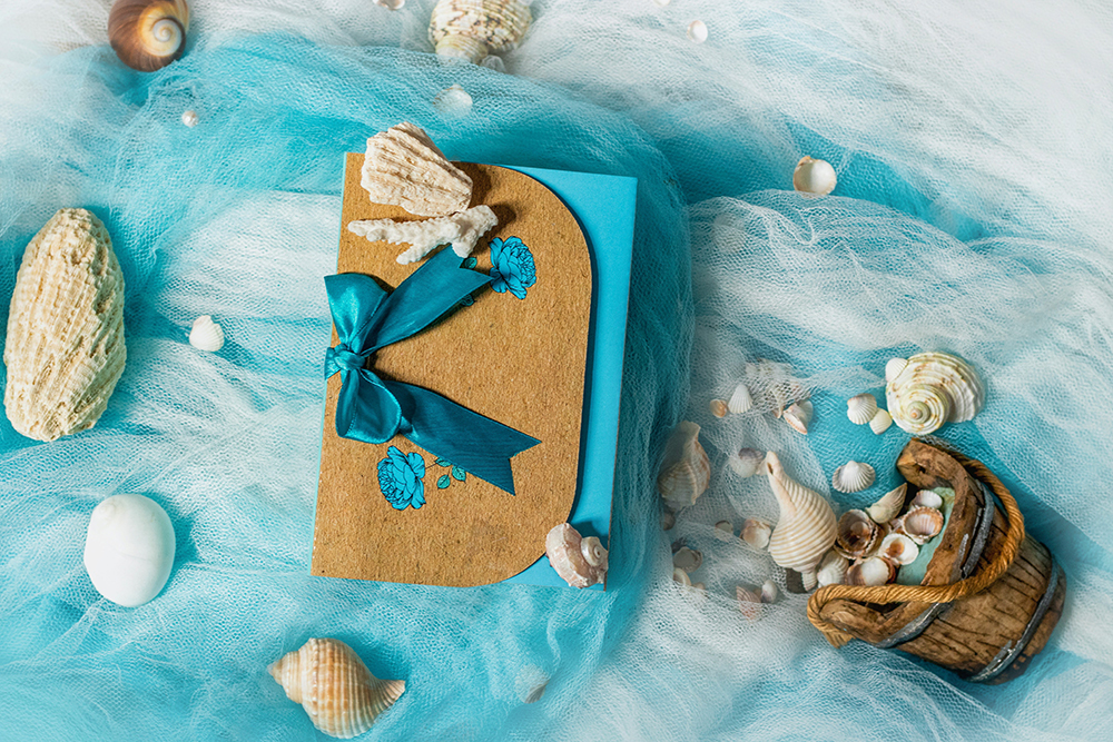 A seascape comprised of shells and pebbles scattered across blue and white netting