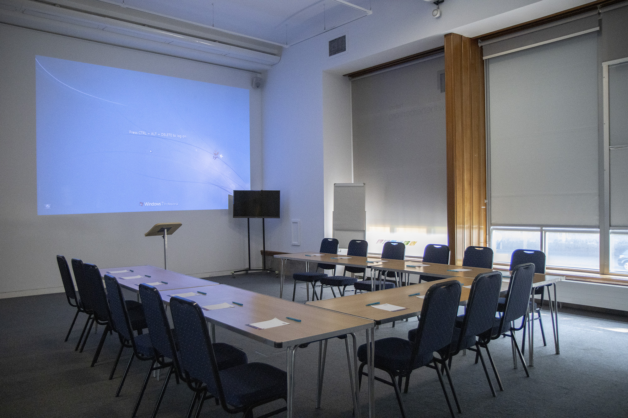 A photograph of Learning Space 2 set up for a meeting with 15 seats, a lectern and a projector