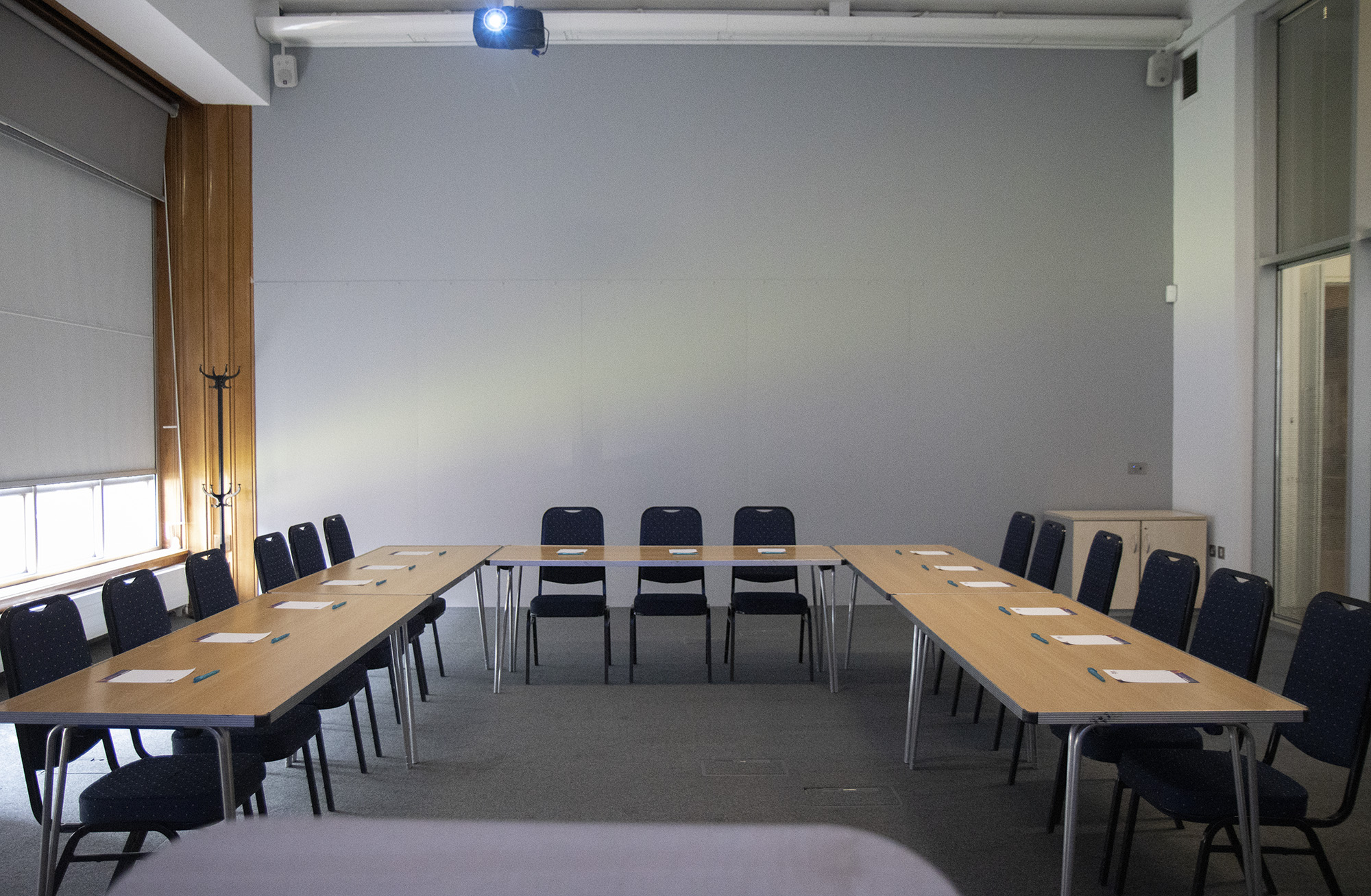 A photograph of Learning Space 2 set up for a meeting with 15 seats and a projector