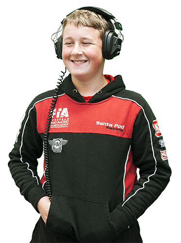 A teeange male smiles whilst listening to music on his headphones