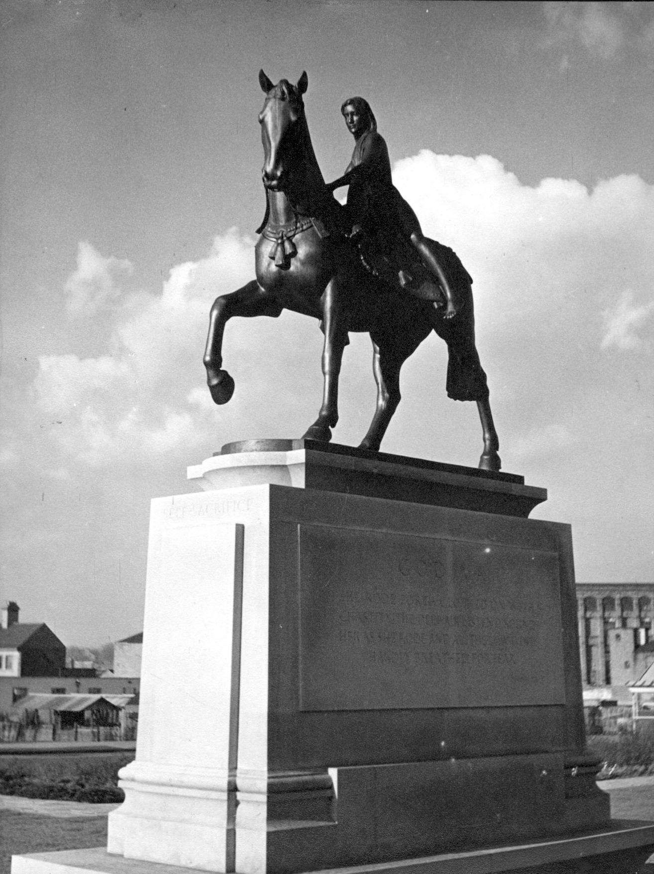 A black and white photograph of Sir William Reid Dick's statue of Lady Godiva on horseback, situated in Broadgate, Coventry city centre.