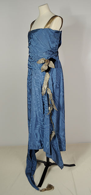 1920s blue tafetta flapper dress with gold straps and a gold flower embellishment at the waist