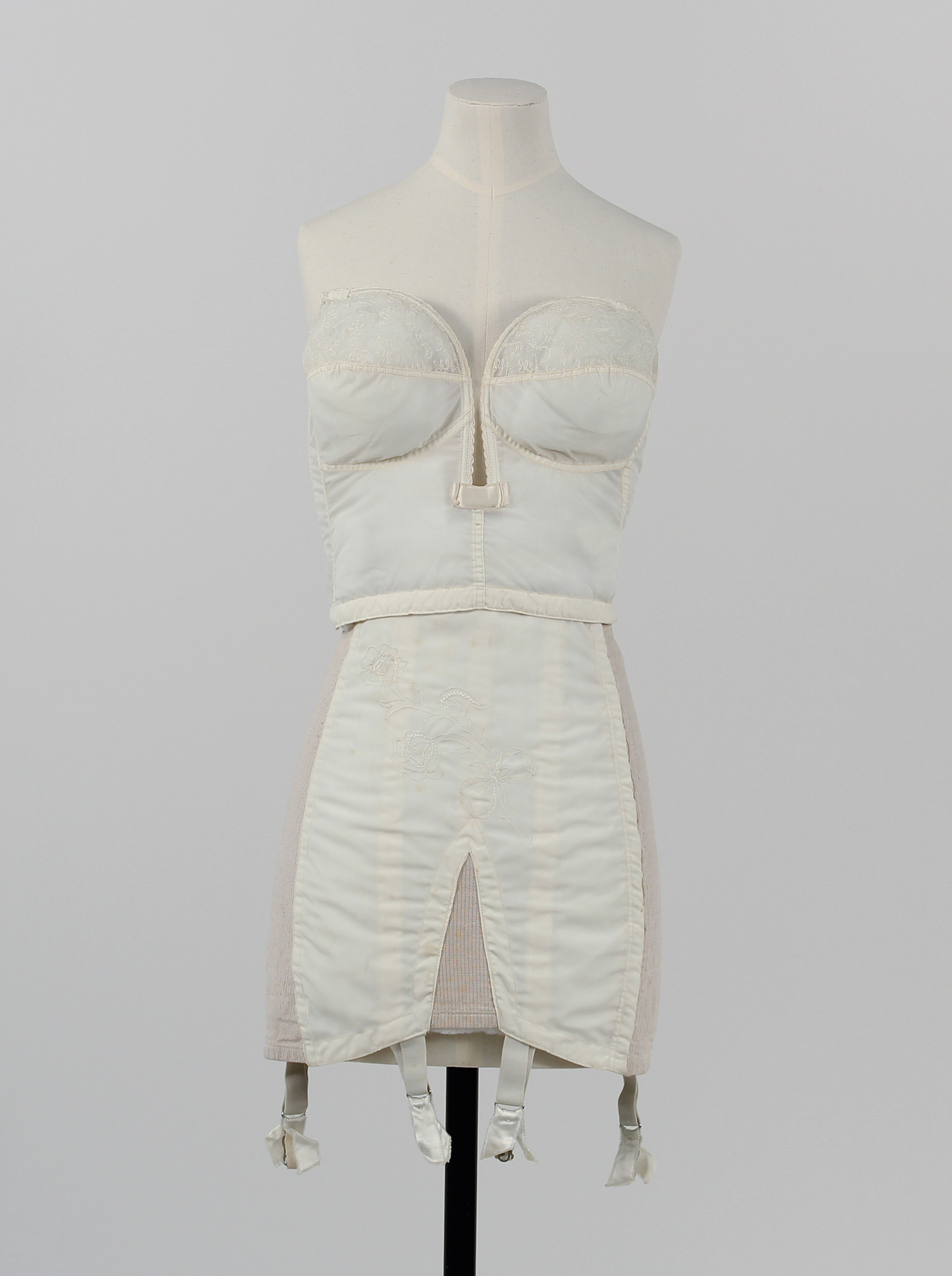 Women's 1950s underwear set consisting of a strapless, longline bra, girdle and suspenders