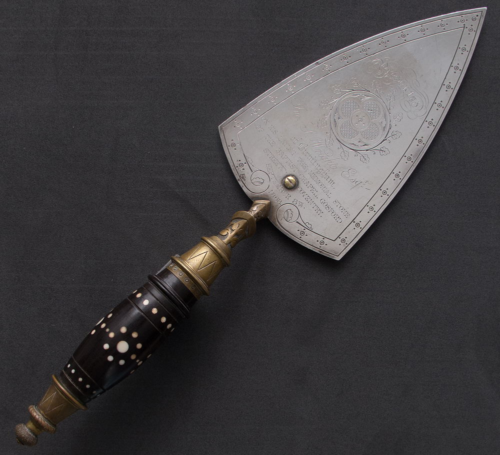 an ornate trowel with engraved writing of the maker, and details of the ceremony