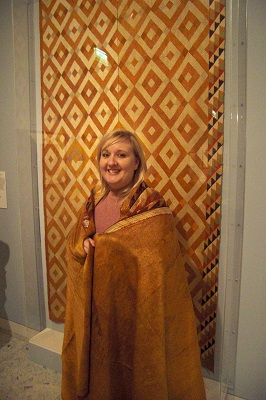 a smiling woman tries on a decorative wrap
