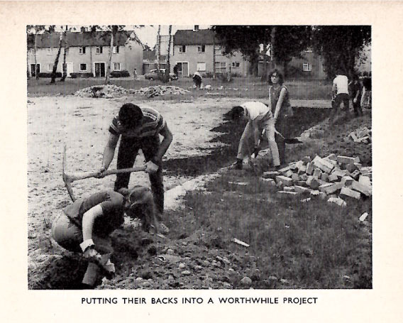 Youth group members starting a gardening project, with the headline, "Putting their backs into a worthwhile project"