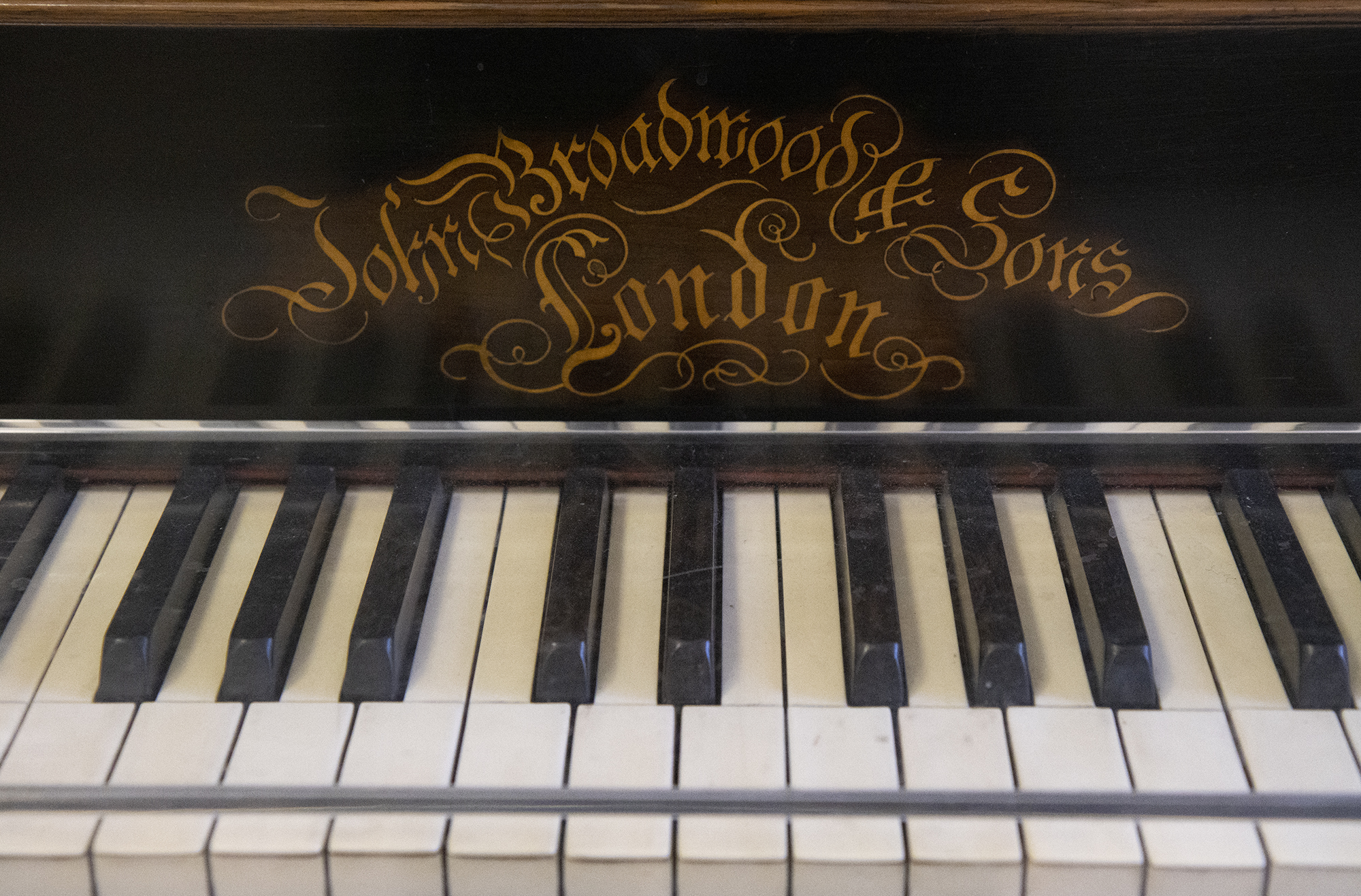A close-up of a section of the piano keys, with the manufacturer's name in ornate, swirling lettering, 'John Broadwood & Sons | London' 