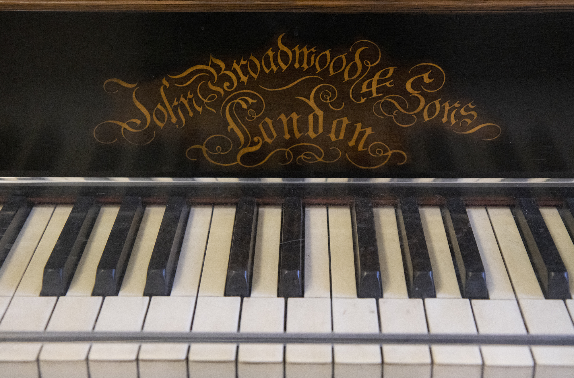 A close-up of a section of the piano keys, with the manufacturer's name in ornate, swirling lettering, 'John Broadwood & Sons | London'
