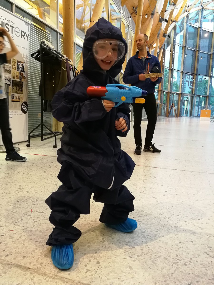 child dressed in boiler suit and goggles with water pistol