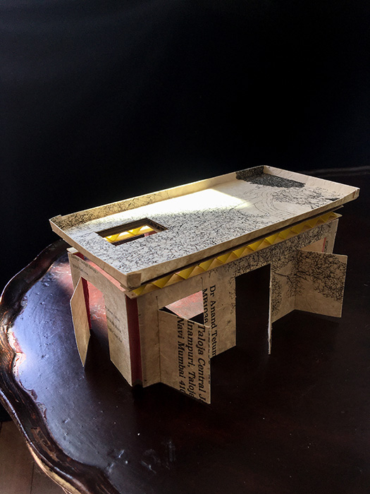A photograph of a sculpture from Sofia Karim's Architecture of Disappearance - showing a model building made of paper