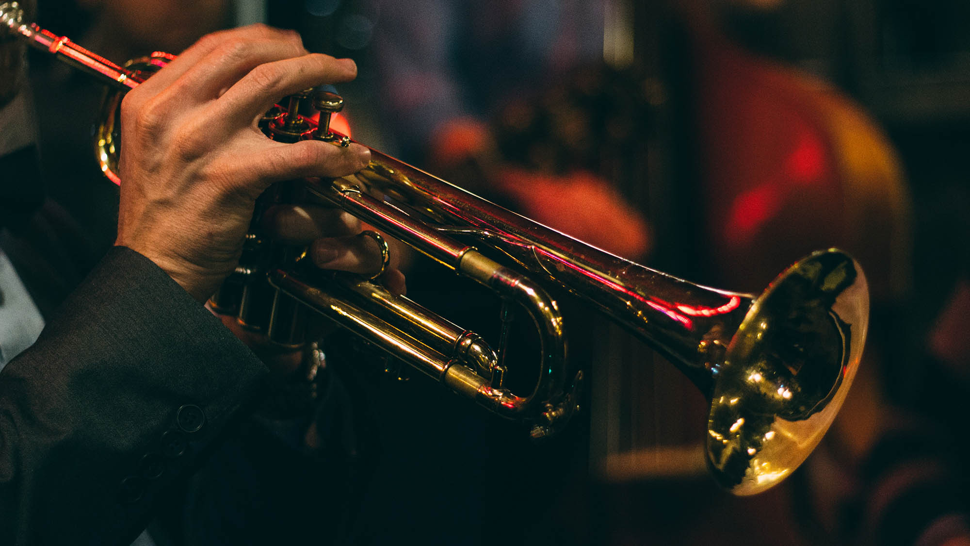 A photo of a trumpet with hands operating it