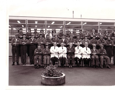 a black and white group photo of men in overalls