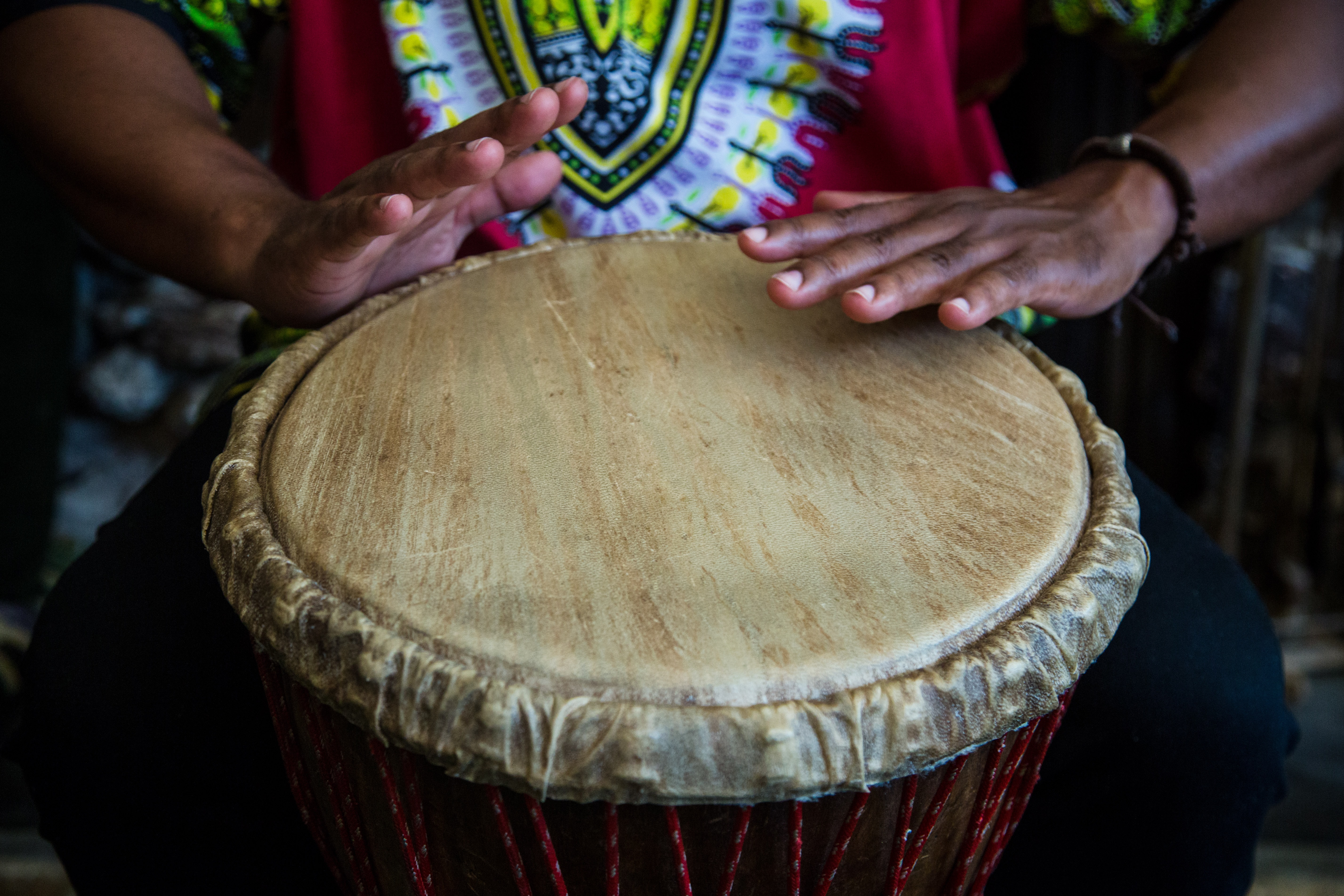 A close up of a pair of hands playing a hand drum